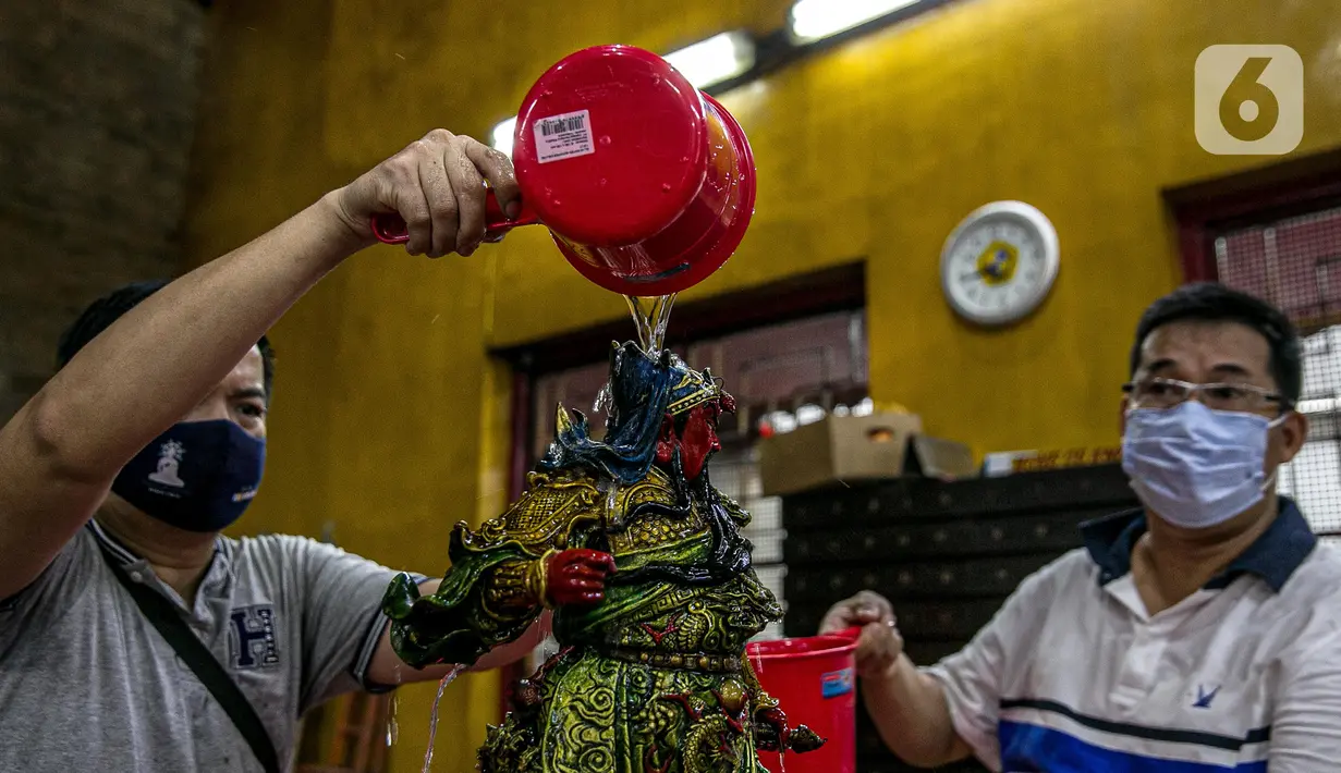 Para jemaat membersihkan patung yang ada di Vihara Amurva Bhumi, Jakarta, Kamis (4/2/2021). Ritual mencuci patung dewa serta bersih-bersih ini dilakukan dalam rangka menyambut perayaan Tahun Baru Imlek 2572. (Liputan6.com/Faizal Fanani)