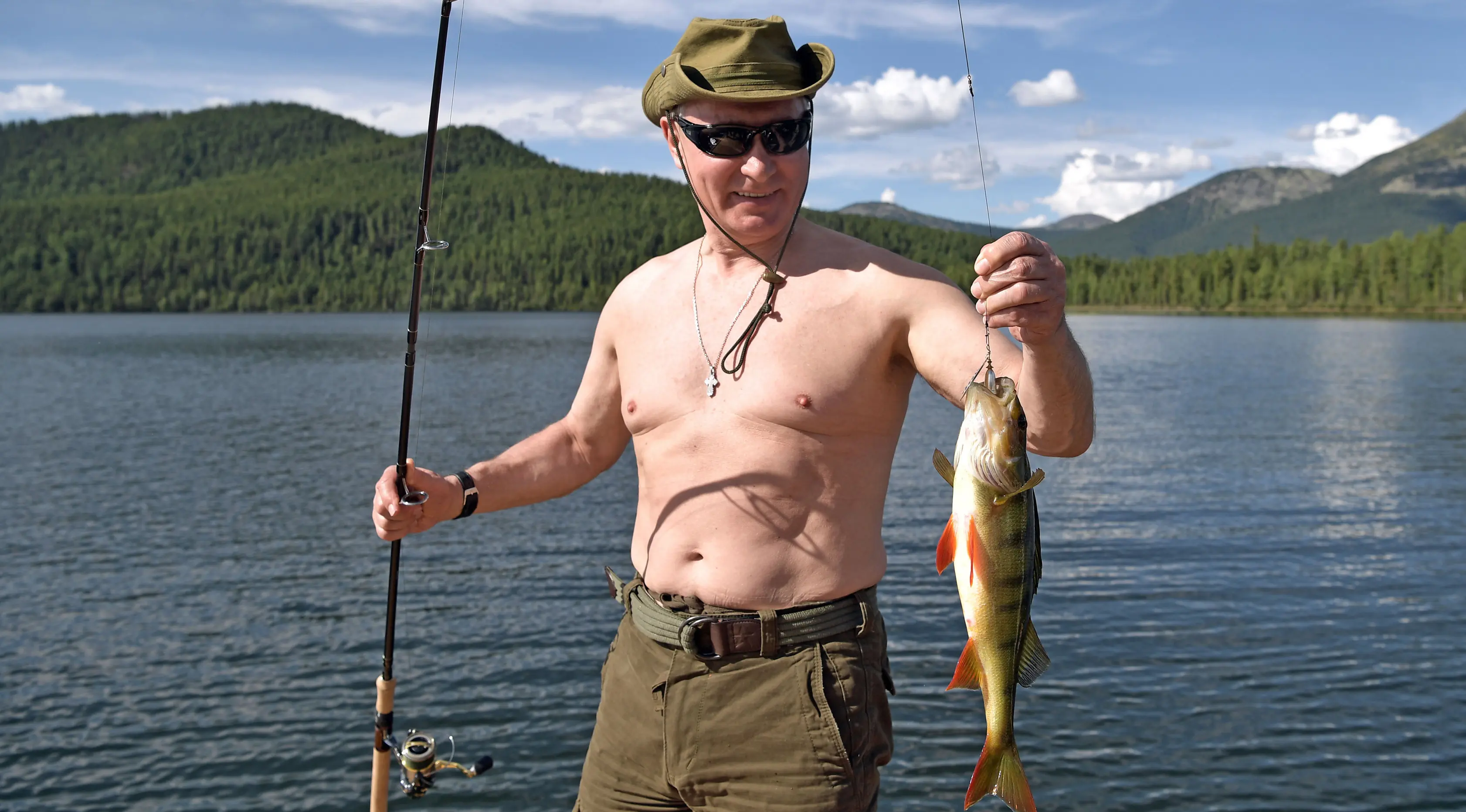 Presiden Rusia Vladimir Putin menunjukkan ikan yang didapat saat memancing selama liburan mini di kawasan Siberia Tyva. Foto dirilis oleh biro pers Kremlin, pada 5 Agustus 2017. (Alexei Nikolsky / Sputnik, Foto Kolam Kremlin via AP)