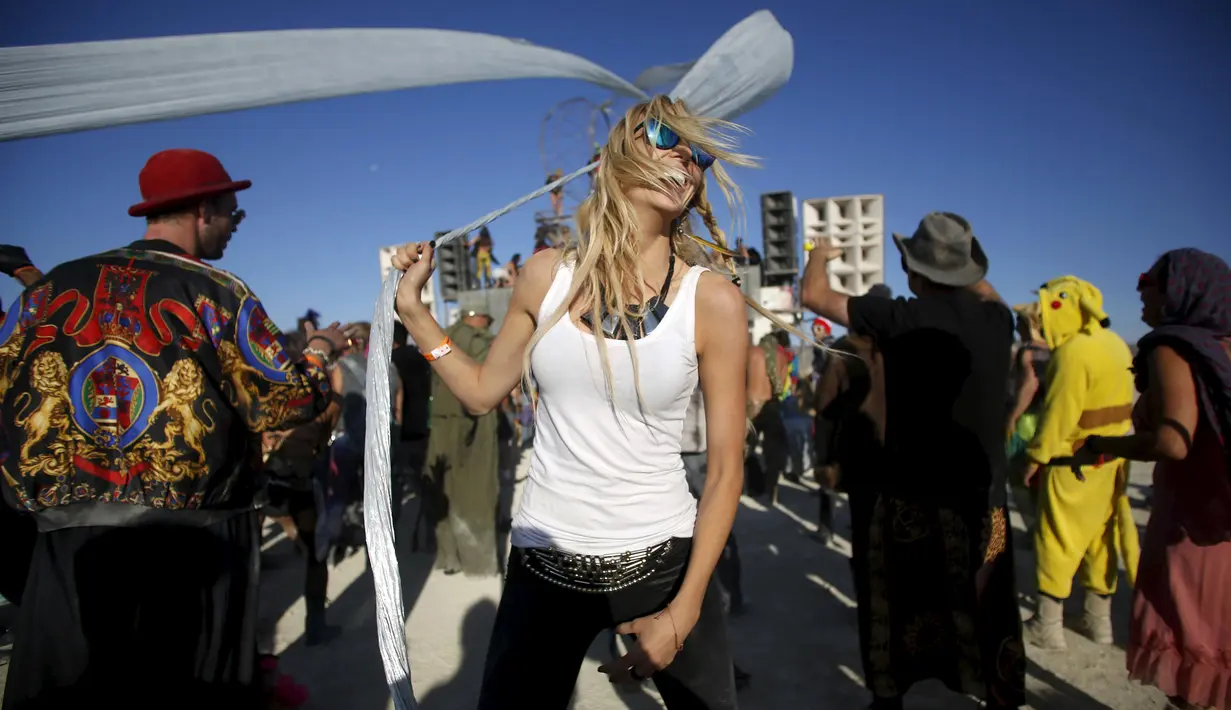 Lauren Gilligan menari di depan instalasi Robot Heart dalam festival musik dan seni Burning Man 2015 di Gurun Black Rock, Nevada, (1/9/2015). Partisipan dari seluruh dunia hadiri festival seni unik ini selama sepekan. (REUTERS/Jim Urquhart)