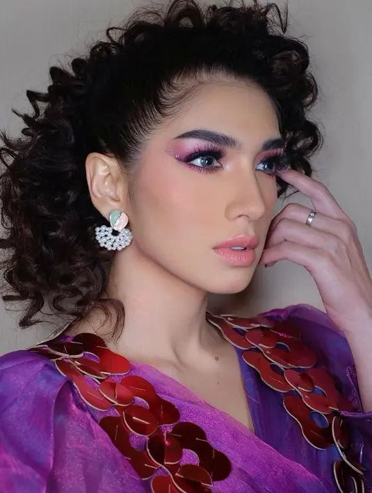 Cantik dan segar, Angel Karamoy menghadirkan makeup bold bernuansa keunguan. Rambutnya dibuat ikal dengan outfit ungu terang, eye makeup yang apik dan tajam menyempurnakan keseluruhan penampilannya. Foto: Instagram.