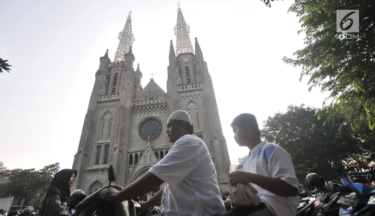 Umat muslim yang akan menunaikan salat Idul Adha di Masjid Istiqlal memarkirkan kendaraan mereka di halaman Gereja Katedral, Jakarta, Minggu (11/8/2019). Untuk membantu jemaah melaksanakan ibadah, Katedral menyediakan lahan parkirnya dan mengundurkan waktu ibadah Misa. (merdeka.com/Iqbal S Nugroho)