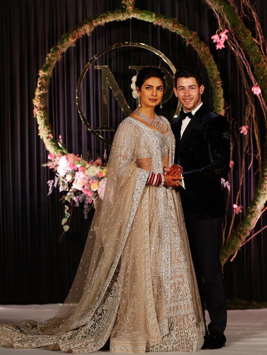 Aktris Bollywood Priyanka Chopra dan musisi AS Nick Jonas berpose saat resepsi pernikahan mereka di New Delhi, India, Selasa (4/12). Upacara pernikahan kedua mereka digelar secara Hindu pada 2 Desember 2018. (AP Photo/Altaf Qadri)