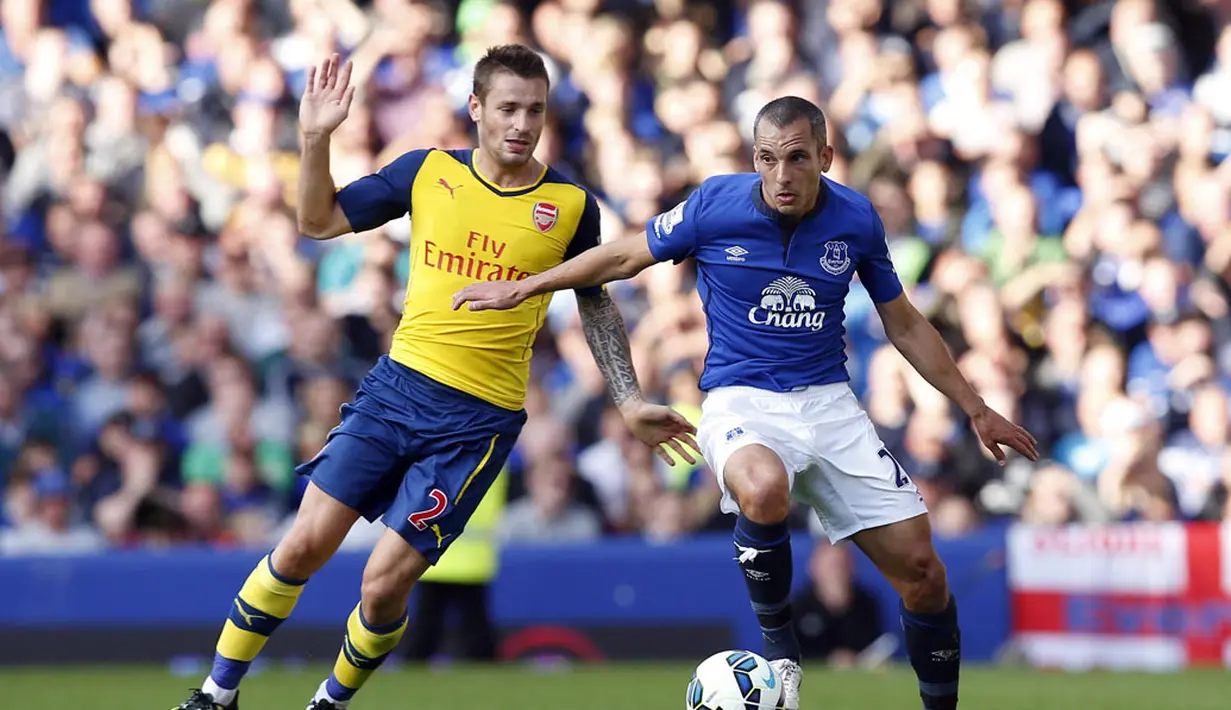Gelandang Everton, Leon Osman (kanan), mencoba menghindari kejaran pemain Arsenal, Mathieu Debuchy, saat berlaga dalam lanjutan Liga Primer Inggris di Stadion Goodison Park, (24/8/2014). (REUTERS/Andrew Yates)