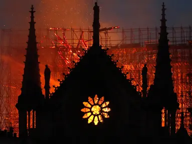 Api dan asap mengepul dari kebakaran Gereja Katedral Notre-Dame di pusat kota Paris, Prancis, pada Senin (15/4) waktu setempat. Api dengan cepat melalap bagian atap gereja yang dibangun pada abad ke-12 itu dan merupakan salah satu ikon wisata di Paris. (AP Photo/Thibault Camus)