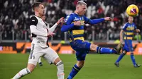 Gelandang Juventus, Aaron Ramsey, berebut bola dengan bek Parma, Simone Iacoponi, pada laga Serie A di Stadion Juventus, Turin, Minggu (19/1). Juventus menang 2-1 atas Parma. (AFP/Marco Bertorello)