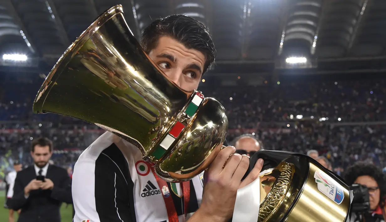 Penyerang Juventus, Alvaro Morata mencium trofi setelah memenangkan pertandingan final Piala Tim Italia melawan AC Milan di Stadion Olimpiade di Roma pada 21 Mei 2016. (AFP/Tiziana Fabi)