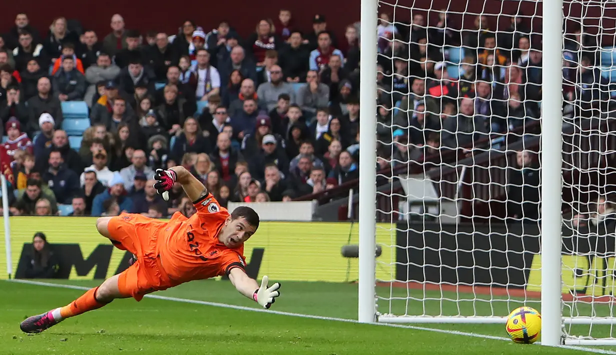 Penjaga gawang Aston Villa, Emiliano Martinez tidak dapat menjagkau bola tendangan dari pemain Arsenal pada pertandingan pekan ke-24 Premier League 2022/2023 yang berlangsung di Villa Park, Sabtu (18/2/2023). (AFP/Geoff Caddick)