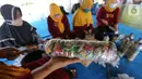 Warga penggiat bank sampah mengolah kerajinan 'eco brick' dari limbah sampah kemasan dan botol plastik di Pulau Harapan, Kabupaten Kepulauan Seribu Jakarta, Sabtu (22/5/2021). Sampah palstik yang dipadatkan ke dalam botol dibentuk menjadi kerajinan meja dan kursi. (Liputan6.com/Fery Pradolo)