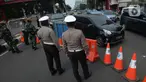 Petugas melakukan penjagaan di kawasan yang ditutup saat penyekatan di ruas jalan Mampang Prapatan, Jakarta, Kamis (15/7/2021). Mampang menjadi salah satu jalan yang masuk dalam penyekatan baru pada Pemberlakuan Pembatasan Kegiatan Masyarakat (PPKM) darurat di Ibu Kota. (merdeka.com/Imam Buhori)