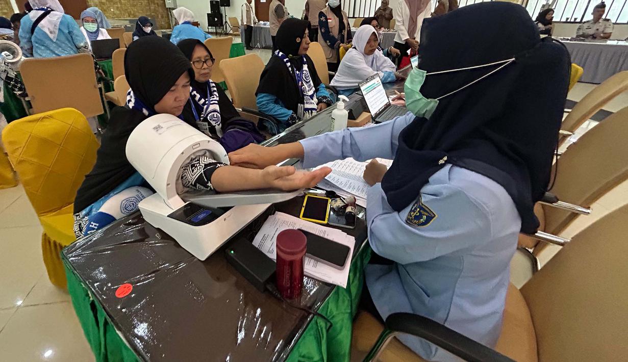 Sebagai informasi, secara nasional, pemberangkatan jemaah haji Indonesia gelombang pertama akan dilakukan secara bertahap mulai tanggal 22 April 2026 dengan tujuan awal Kota Madinah. Tampak dalam foto, petugas memeriksa kesehatan calon haji setibanya di Asrama Haji Pondok Gede, Jakarta, Selasa (21/4/2026). (merdeka.com/Arie Basuki)