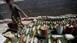 Tentara Irak menunjukkan amunisi, mortir dan bahan peledak lainnya milik ISIS yang berhasil ditemukan di wilayah barat Mosul, Kamis (6/4). (AFP Photo / Ahmad Gharabli)