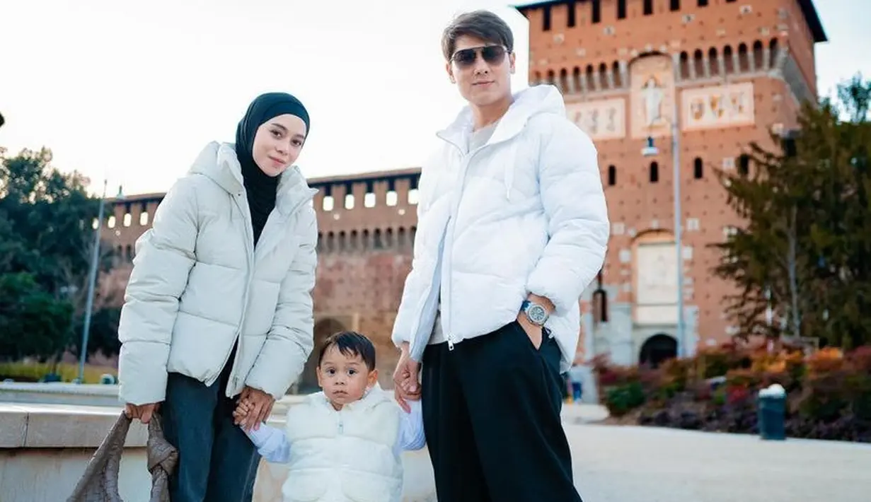 Lesti Kejora mengenakan padding jaket putih yang serasi dengan Rizky Billar dan anaknya. Ia pun memadukan dengan celana denim dan kerudung hitamnya. [@lestikejora]