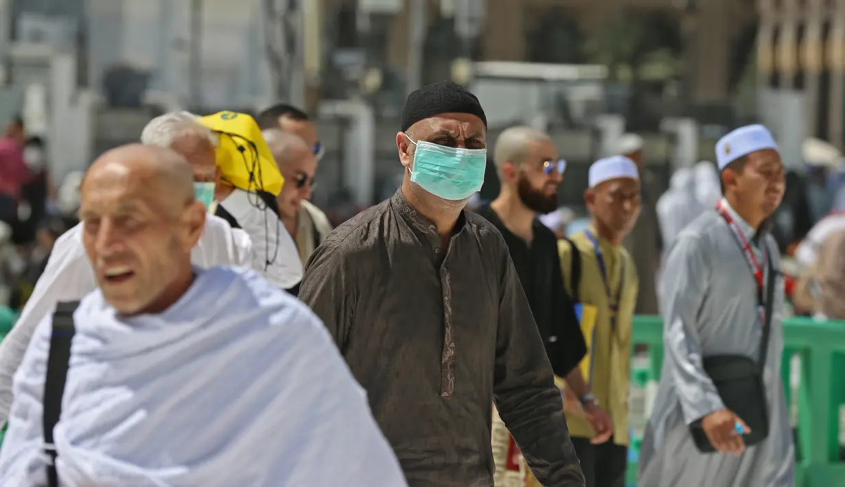 Umat Muslim mengenakan masker di Masjidil Haram, kota suci Makkah, Kamis (27/2/2020). Suasana Masjidil Haram berjalan sebagaimana biasanya pascapengumuman Pemerintah Arab Saudi melarang sementara jemaah umrah ke Tanah Suci terkait pencegahan penyebaran virus korona. (Abdulghani BASHEER/AFP)