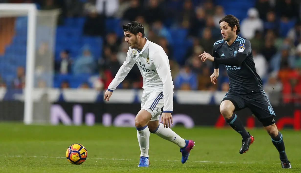 Pemain Real Madrid, Alvaro Morata (kiri) menggiring bola melewati pemain Real Sociedad, Esteban Granero pada laga La Lga Spanyol di Santiago Bernabeu stadium, Madrid (29/1/2017). Madrid menang 3-0. (AP/Francisco Seco)