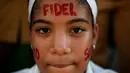 Seorang anak melukis wajah mereka dengan tulisan Fidel saat menunggu mobil yang membawa abu mantan pemimpin Revolusi Kuba, Fidel Castro, lewat di Bayamo, Kuba (3/11). (Reuters/Enrique De La Osa)
