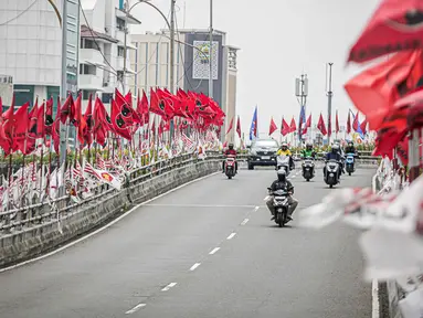 Sejumlah pengendara melintasi flyover yang dipenuhi bendera partai politik di Jakarta, Senin (15/1/2024). Sejumlah pengguna jalan mengeluhkan banyaknya bendera partai politik di kanan-kiri flyover yang dapat membahayakan pengguna jalan, terutama roda dua, serta merusak keindahan jalanan menjadi terlihat kumuh. (Liputan6.com/Faizal Fanani)