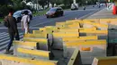Pejalan kaki menghindari beton pembatas jalan yang diletakkan di atas trotoar Jalan Medan Merdeka Utara, Jakarta, Kamis (25/7/2019). Pembatas jalan yang berada tidak pada tempatnya mengganggu kenyamanan pejalan kaki yang melintasi trotoar jalan tersebut. (Liputan6.com/Helmi Fithriansyah)