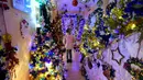 Seorang gadis berdiri di antara pohon-pohon Natal yang menghiasi rumah keluarga Thomas Jeromin di Rinteln, Jerman, Minggu (8/12/2019). Thomas Jeromin memenuhi rumahnya dengan 350 pohon Natal di hampir tiap sudut rumah, mulai dari ruang tamu, dapur sampai kamar mandi. (Ina FASSBENDER/AFP)