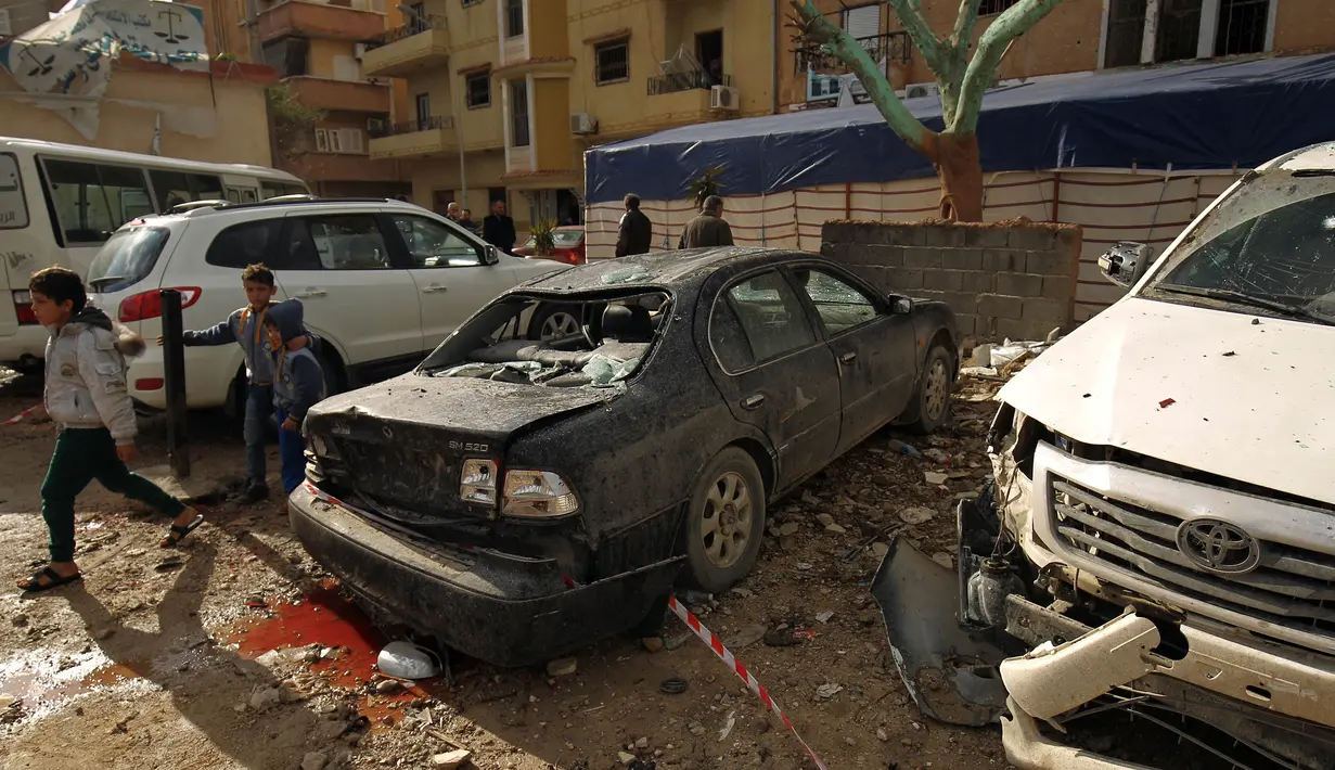 Sejumlah anak-anak beraktivitas di sekitar lokasi serangan bom mobil ganda di Kota Benghazi, Libya, Rabu (24/1). Seorang pejabat intelijen Libya, Mahdi al-Fellah, dilaporkan terluka. (AFP PHOTO/Abdullah DOMA)