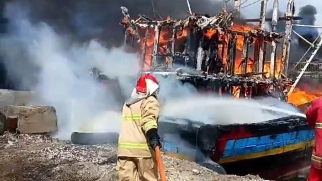 Petugas Pemadam kebakaran berjibaku memadamkan kapal ikan yang terbakar diu Pelabuhan Massami Banyuwangi (Istimewa)