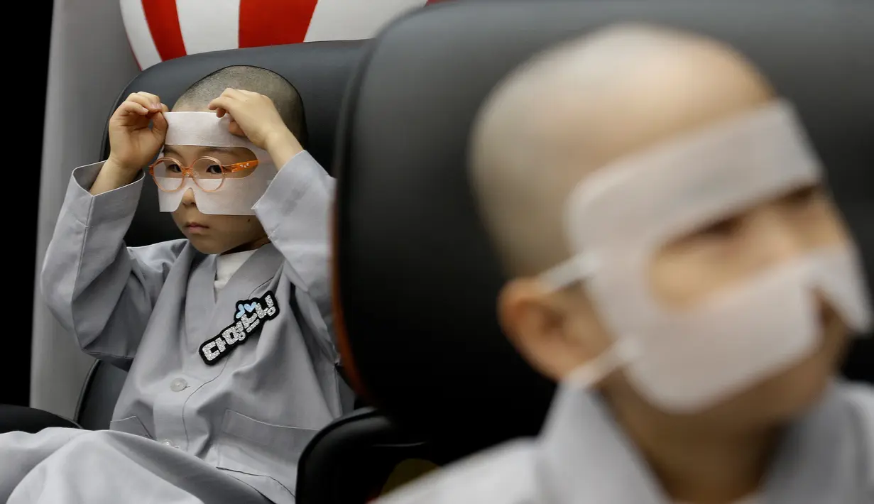 Anak lelaki berkepala botak bersiap menggunakan perangkat Virtual Reality (VR) sebelum mencoba layanan 5G di tempat pengalaman LG UPlus 5G di Seoul, Korea Selatan (7/5/ 2019). Perayaan ulang tahun Buddha akan jatuh pada 12 Mei mendatang. (AP Photo/Ahn Young-joon)