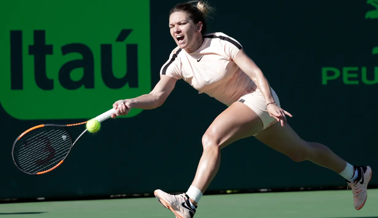 Petenis Rumania, Simona Halep melakukan servis ke arah petenis Prancis, Oceane Dodin pada babak kedua Miami Terbuka di Crandon Park, Kamis (22/3). Halep dipaksa bermain tiga set dan meloloskan diri ke babak ketiga Miami Open. (AP/Lynne Sladky)
