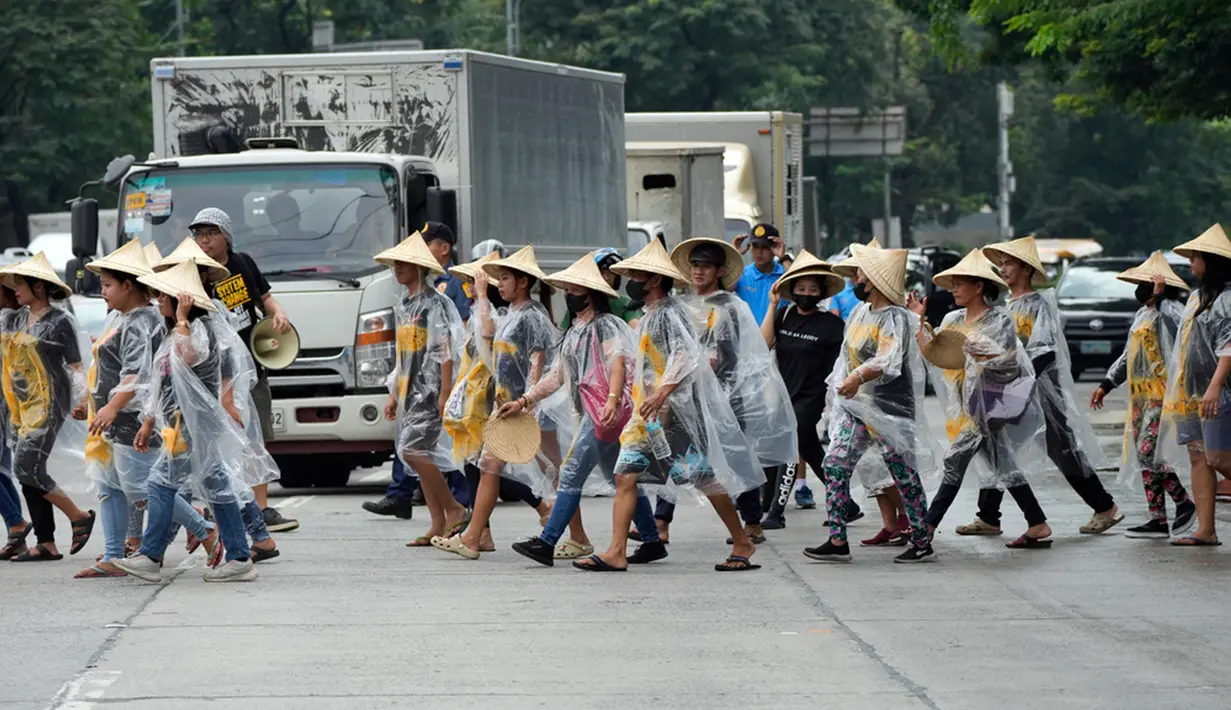 Para pengunjuk rasa yang mengenakan lembaran plastik menyeberang jalan saat mereka bergabung dalam demonstrasi global untuk mengakhiri bahan bakar fosil di Kota Quezon, Filipina, Jumat (15/9/2023). Global Climate Strike digelar sekitar dua bulan sebelum KTT Iklim PBB, COP28, yang bakal digelar pada November ini di Uni Emirat Arab (UEA). (AP Photo/Aaron Favila)