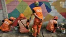 Petugas PPSU mengecat saat pembuatan mural pada tembok yang berada di pinggir Jalan Landasan Pacu, Jakarta, Rabu (11/7). Pengecatan dan pembuatan mural ini dalam rangka mempercantik kawasan serta menyambut Asian Games 2018. (Merdeka.com/Iqbal S. Nugroho)