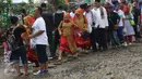 Pengunjung menghindari jalan yang becek pada Festival Lebaran Betawi IX, Jakarta, (14/8). Festival diramaikan dengan rumah adat Betawi dari masing-masing pemkot  administrasi Jakarta serta Kabupaten Kepulauan Seribu. (Liputan6.com/Immanuel Antonius)