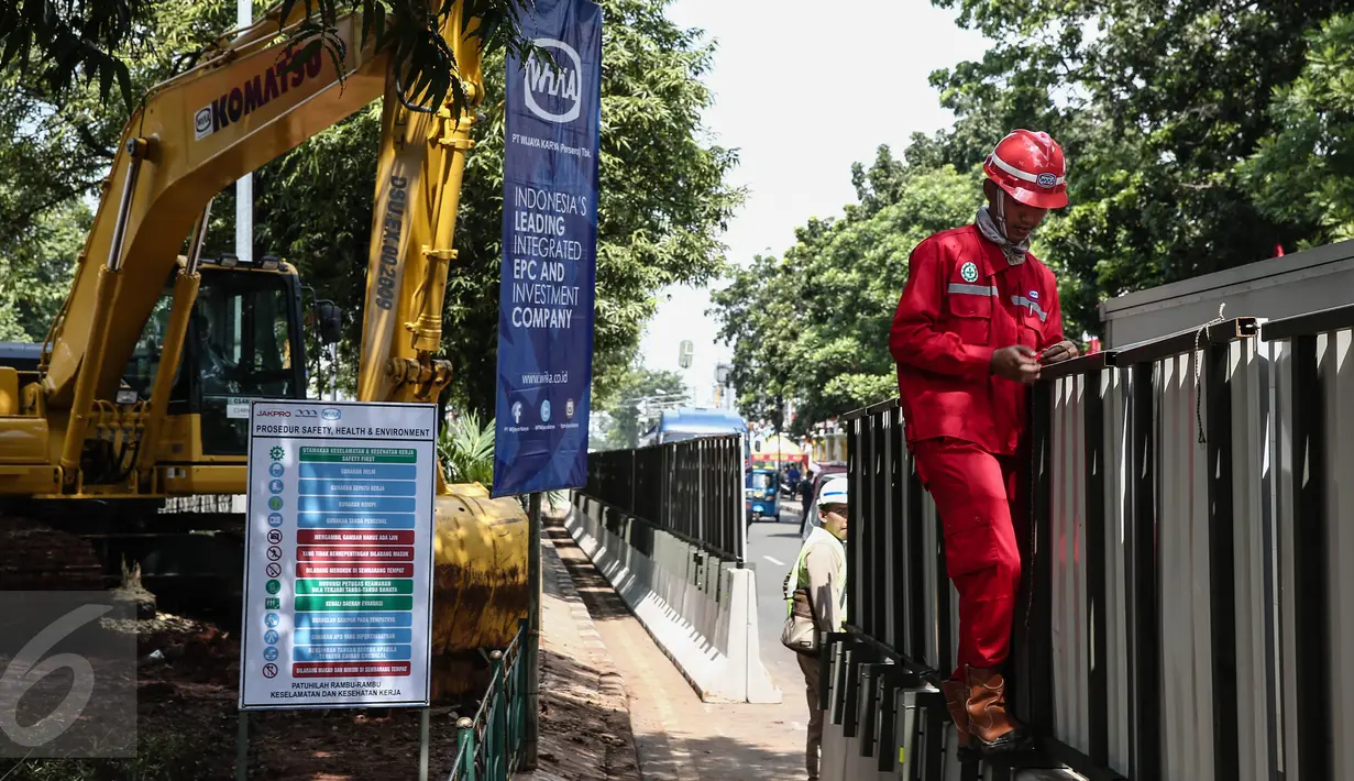 Pekerja memasang spanduk proyek Light Rail Transit (LRT) Velodrome di kawasan Rawamangun, Jakarta, Rabu (22/6). Dana tahap awal pembangunan LRT tersebut sekitar Rp 4,5 triliun. (Liputan6.com/Faizal Fanani)