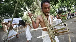 Kelompok Sajinah Seniman Solo melakukan adegan pada pertunjukan berjudul 'Menuju Putih' di Taman Suropati, Jakarta, Rabu (23/12). Pertunjukan itu merupakan bentuk ekspresi seniman dalam mewujudkan cita-cita Indonesia (Liputan6.com/Immanuel Antonius)