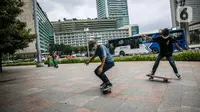 Warga bermain skateboard di trotoar Jalan Sudirman-Thamrin, Jakarta, Jumat (5/3/2021). Izin penggunaan trotoar sebagai tempat bermain skateboard keluar usai Gubernur DKI Jakarta Anies Baswedan bertemu dengan salah satu skateboarder Jakarta. (Liputan6.com/Faizal Fanani)