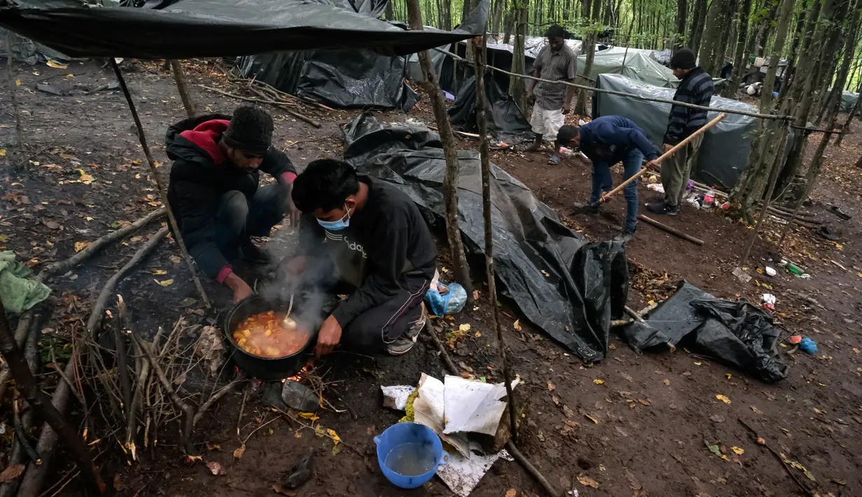 Migran memasak di kamp darurat di hutan di luar Velika Kladusa, Bosnia pada 26 September 2020. Bosnia menjadi salah satu tempat singgah para imigran dan pengungsi dalam perjalanannya ke Eropa Barat. (AP Photo/Kemal Softic)