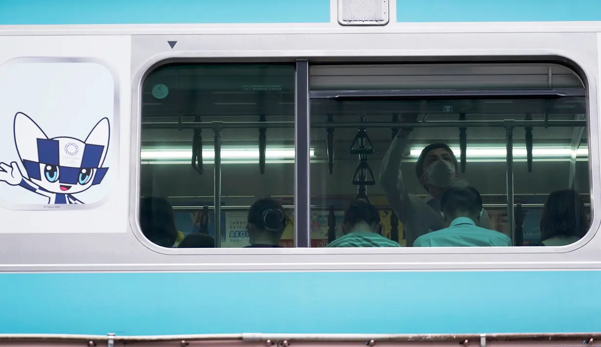 Seorang pria yang mengenakan topeng mencegah penyebaran coronavirus baru berada di dalam kereta api di Tokyo, Senin, (20/7/2020). Ibukota Jepang hari Senin mengkonfirmasi lebih dari 160 kasus virus corona baru. (AP Photo/Eugene Hoshiko)