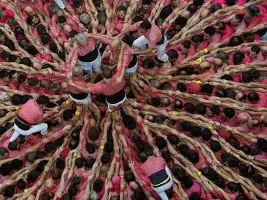 Anggota "Colla Vella dels Xiquets de Valls" membentuk menara manusia selama Kompetisi Tower Manusia di Tarragona, Spanyol, Minggu (7/10). Tradisi "Castells" atau "Menara Manusia" ini berasal dari tradisi di Catalonia pada abad ke-18. (AP/Emilio Morenatti)