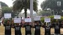 Aktivis menunjukkan pesan tuntutan saat menggelar aksi #BersihkanIndonesia di depan Istana Merdeka, Jakarta, Senin (19/8/2019). Aktivis menyerukan kebebasan hakiki dari kerusakan lingkungan dengan meninggalkan sumber energi fosil beralih ke energi bersih terbarukan. (Liputa6.com/Angga Yuniar)