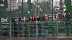 Pengungsi, sebagian besar wanita dan anak-anak, menunggu di perbatasan Ukraina di Medyka, Polandia, Sabtu (5/3/2022). Mereka melarikan diri dari invasi Rusia di Ukraina. (AP Photo/Visar Kryeziu)