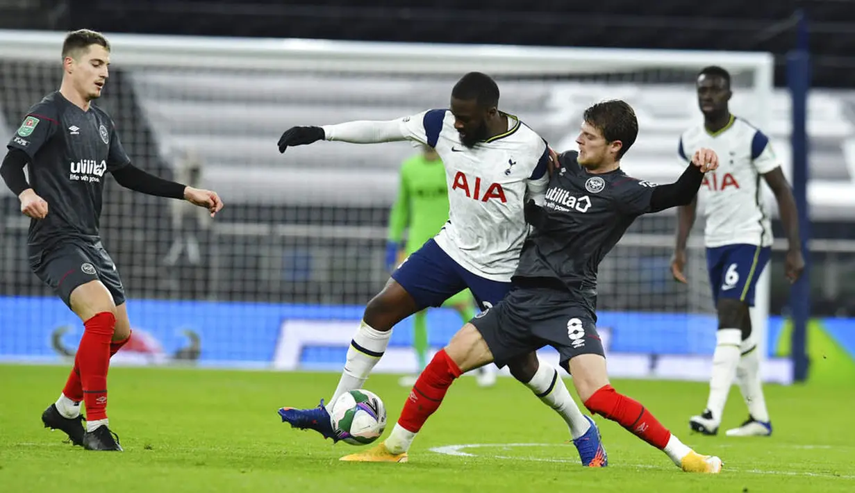 Pemain Tottenham Hotspur, Tanguy Ndombele, berusaha melewati pemain Brentford, Mathias Jensen, pada laga Piala Liga Inggris, di London, Rabu (06/01/2021). Spurs menang dengan skor 2-0. (Glyn Kirk/Pool via AP)