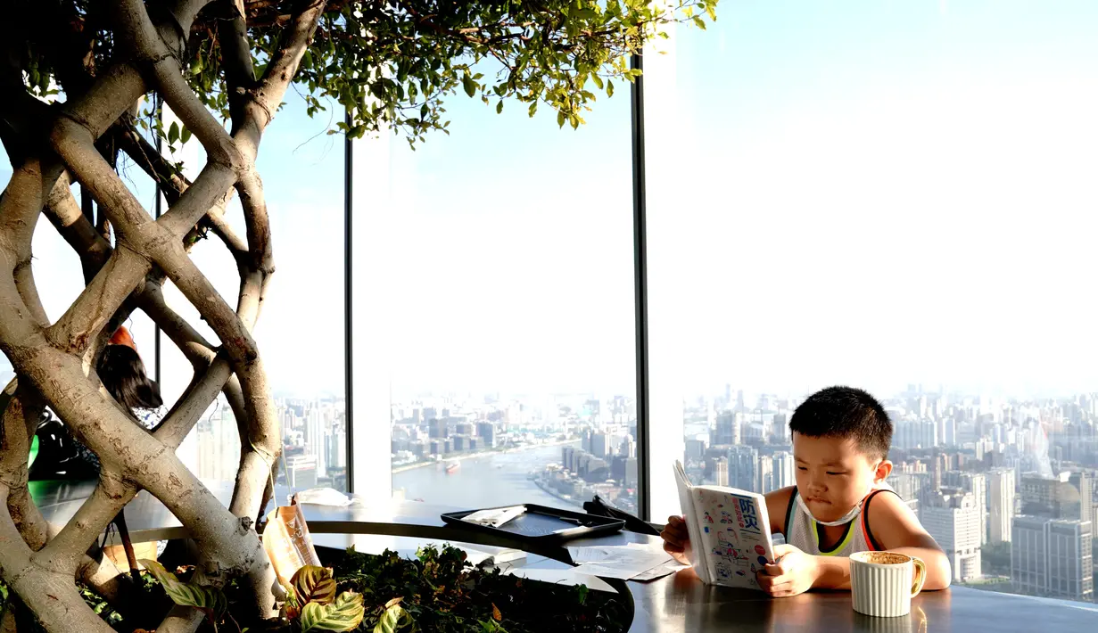 Seorang anak laki-laki membaca di Toko Buku Duoyun di Shanghai, China timur (16/8/2020). Terletak di Menara Shanghai lantai 52, Toko Buku Duoyun telah menarik banyak pengunjung untuk membaca dan menikmati panorama kota. (Xinhua/Zhang Jiansong)