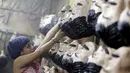 Seorang penjual topeng gembong narkoba "El Chapo" Guzman saat merapikan barang dagangannya disebuah toko di kota Meksiko, Kamis (15/10/2015). "El Chapo" Guzman terkenal setelah melarikan diri dari penjara. (REUTERS/Henry Romero)