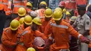 Petugas penyelamat membawa jenazah korban runtuhnya bangunan di Mumbai, India (31/8). Pemerintah kota Mumbai mengatakan sedikitnya sembilan orang tewas dalam peristiwa tersebut. (AP Photo / Rafiq Maqbool)