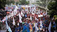 Massa buruh memadati sebagian ruas Jalan Medan Merdeka Barat saat perayaan hari Buruh Internasional di Kawasan Patung Patung Arjuna Wiwaha, Jakarta, Senin (5/1). Ribuan massa buruh ikut dalam perayaan MayDay 2017. (Liputan6.com/Helmi Fithriansyah)