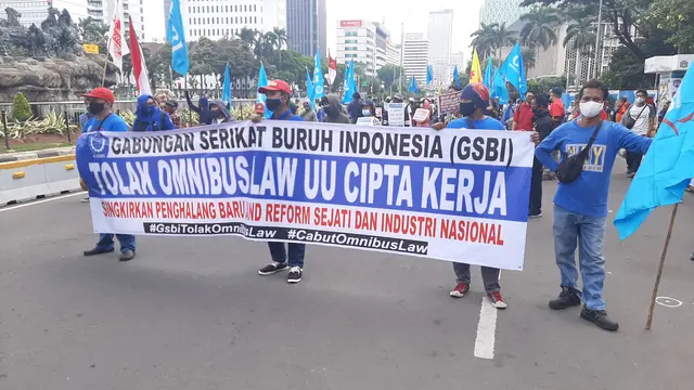 Massa buruh membentangkan spanduk yang bertuliskan penolakan Omnibus Law Cipta Kerja di Patung Kuda, Jakarta Pusat, Selasa (20/10/2020).