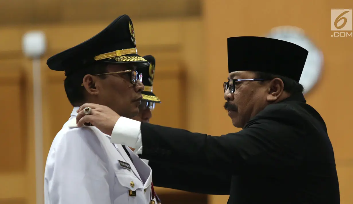 Gubernur Jawa Timur Soekarwo (kanan) melantik Bupati Tulungagung terpilih hasil Pilkada 2018, Syahri Mulyo di Jakarta, Selasa (25/9). Syahri saat ini sudah berstatus tahanan KPK. (Merdeka.com/Imam Buhori)