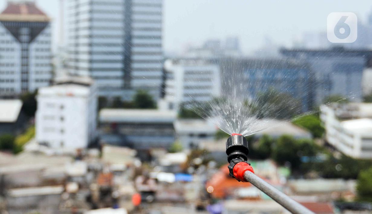 Petugas menyemprotkan air ke udara di Kantor Wali Kota Jakarta Pusat, Selasa (5/9/2023). Alat penyemprot kabut udara (water mist generator) tersebut sebagai langkah untuk mengurangi polusi udara di Jakarta. (Liputan6.com/Herman Zakharia)