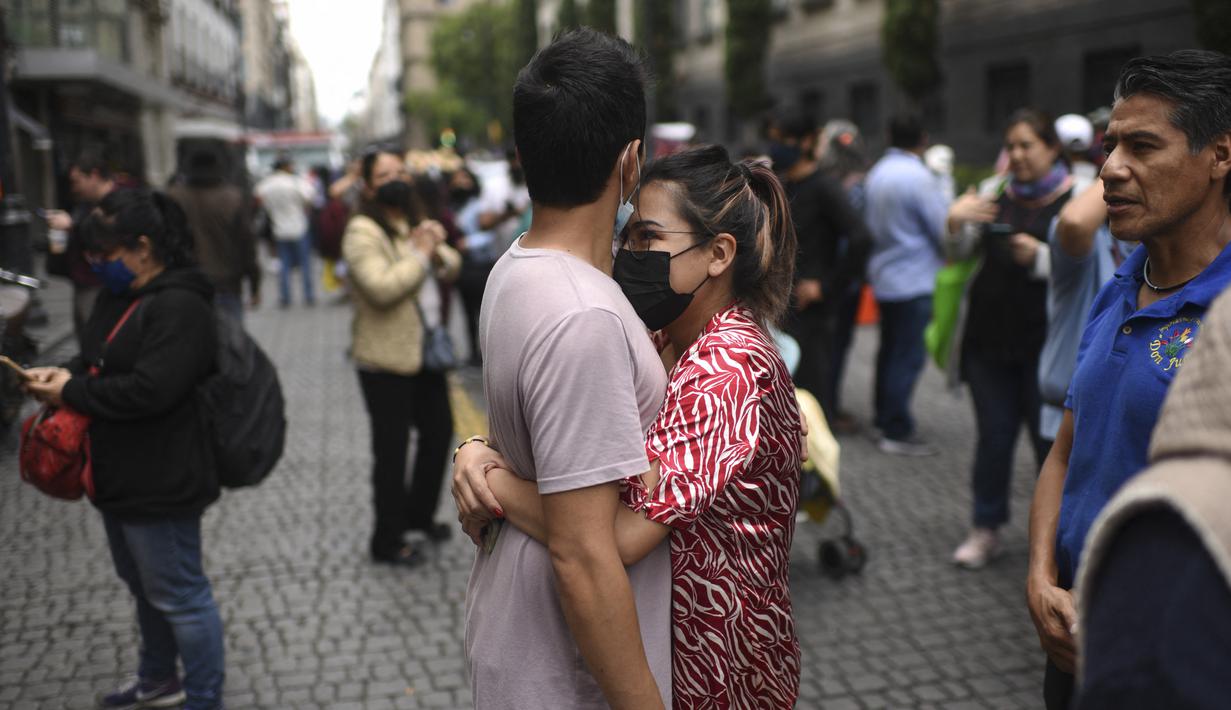 Orang-orang tetap berada di jalan setelah gempa bumi di Mexico City pada Senin (19/9/2022). Setelah gempa, Pusat Peringatan Tsunami Pasifik mengatakan bahwa gelombang yang mencapai hingga 3 meter dapat menghantam Meksiko. (Photo by Pedro PARDO / AFP)