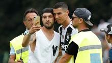 Seorang suporter Juventus berselfie dengan Cristiano Ronaldo selama pertandingan persahabatan antara Juventus A dan tim B, di Villar Perosa, Italia utara, (12/8). Suporter tersebut masuk ke lapangan pada babak pertama. (AP Photo/Antonio Calanni)