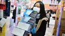 Seorang wanita membeli masker dari apotek di daerah Akihabara Tokyo (27/1/2020). Merebaknya virus corona yang mematikan membuat warga Tokyo berburu masker. (AFP Photo/Charly Triballeau)