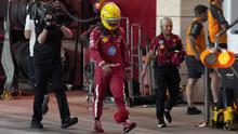 Pembalap Ferrari asal Inggris, Lewis Hamilton (tengah), berjalan di jalur pit selama sesi kualifikasi sprint menjelang Grand Prix Formula Satu Qatar di Sirkuit Internasional Lusail pada 28 November 2025. (Altaf Qadri/ POOL/AFP)