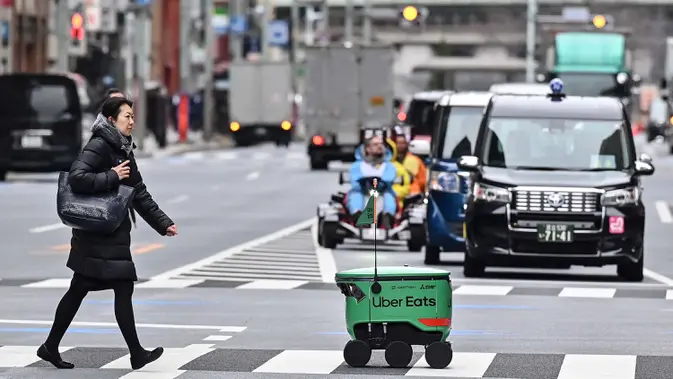 <p>Robot Uber Eats menggunakan sensor untuk menghindari pejalan kaki dan rintangan lainnya. (Richard A. Brooks/AFP)</p>